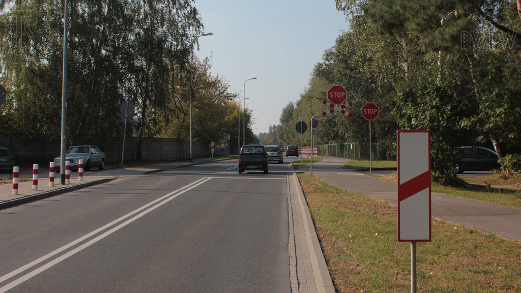 Sytuacja drogowa do pytania: Czy postój pojazdu bezpośrednio za widocznym słupkiem wskaźnikowym jest zabroniony?