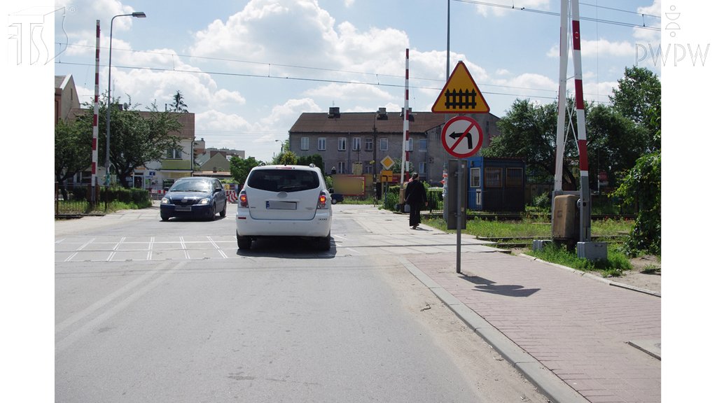 Sytuacja drogowa do pytania: Czy w tej sytuacji, w przypadku unieruchomienia pojazdu z powodu awarii, masz obowiązek niezwłocznie usunąć go z przejazdu, a jeśli jest to niemożliwe, ostrzec o zagrożeniu kierującego pojazdem szynowym?