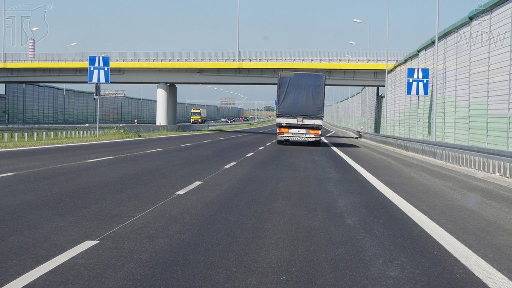 Sytuacja drogowa do pytania: Jaka jest maksymalna dopuszczalna prędkość, z którą masz prawo jechać drogą za tym znakiem, gdy kierujesz autobusem spełniającym dodatkowe warunki techniczne określone w przepisach?