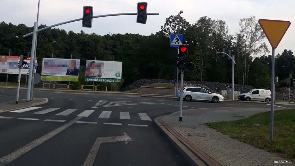 Sytuacja drogowa do pytania: Czy w przedstawionej sytuacji kierujący jest obowiązany zatrzymać pojazd przed jezdnią przy linii złożonej z trójkątów?