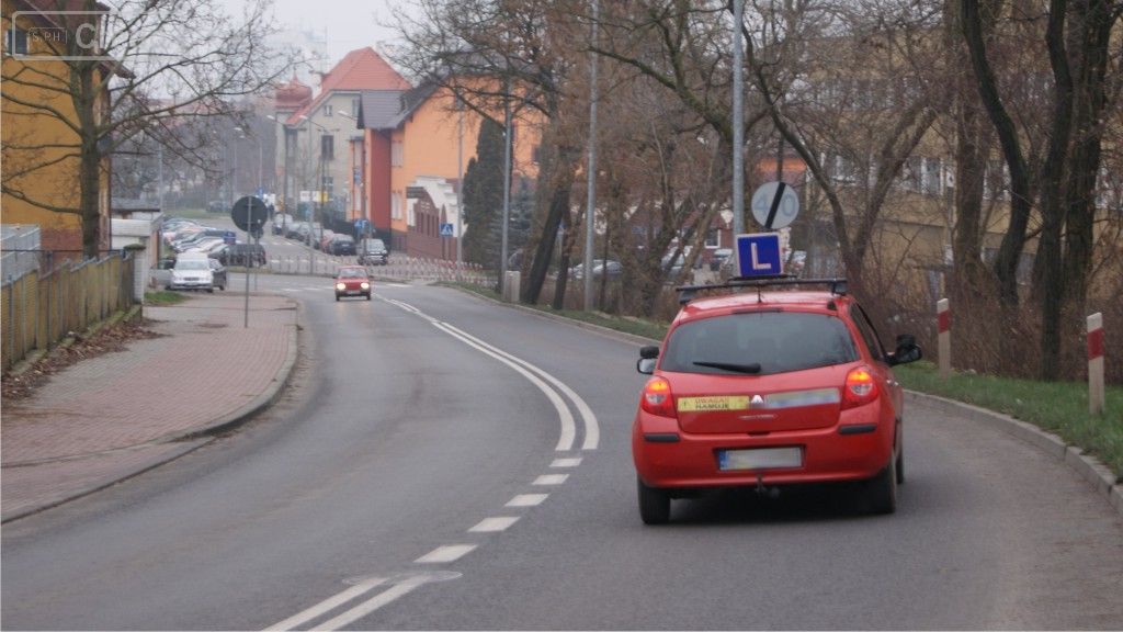 Sytuacja drogowa do pytania: Jak zachowasz się w sytuacji, która zmusi Cię do kontynuuowania jazdy za pojazdem nauki jazdy, bez możliwości bezpiecznego wykonania manewru wyprzedzania?