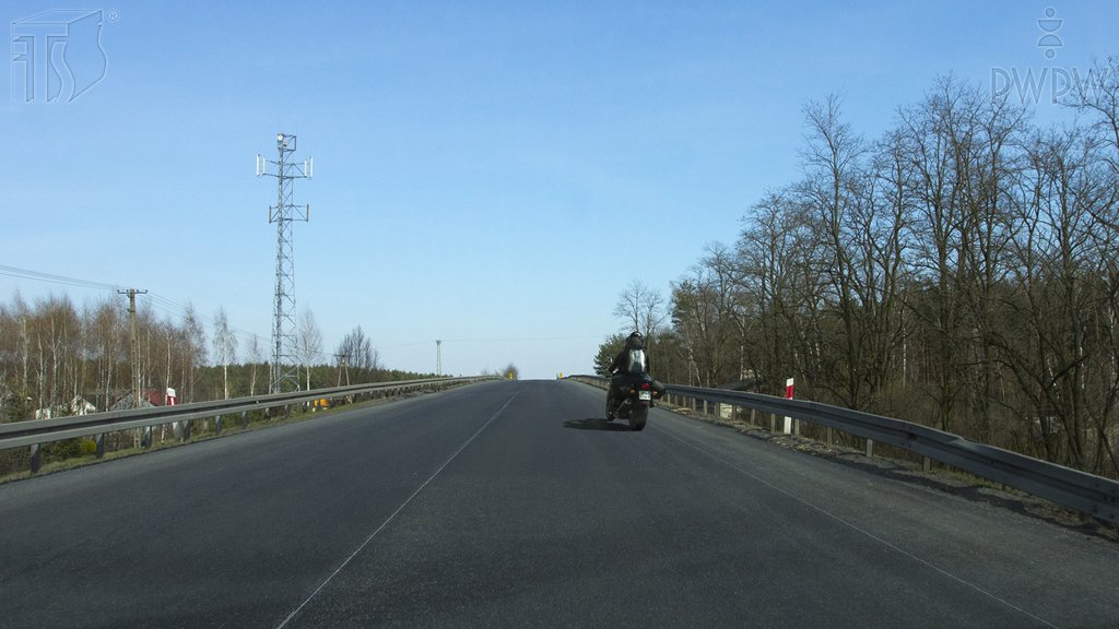 Sytuacja drogowa do pytania: Czy w tej sytuacji, dojeżdżając drogą dwukierunkową do wierzchołka wzniesienia, masz prawo wyprzedzić motocykl?