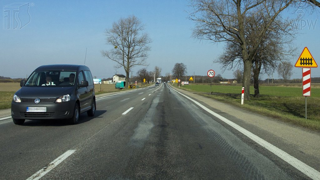 Sytuacja drogowa do pytania: Czy w przedstawionej sytuacji jesteś ostrzegany o zbliżaniu się do przejazdu kolejowego, wyposażonego w zapory lub półzapory?