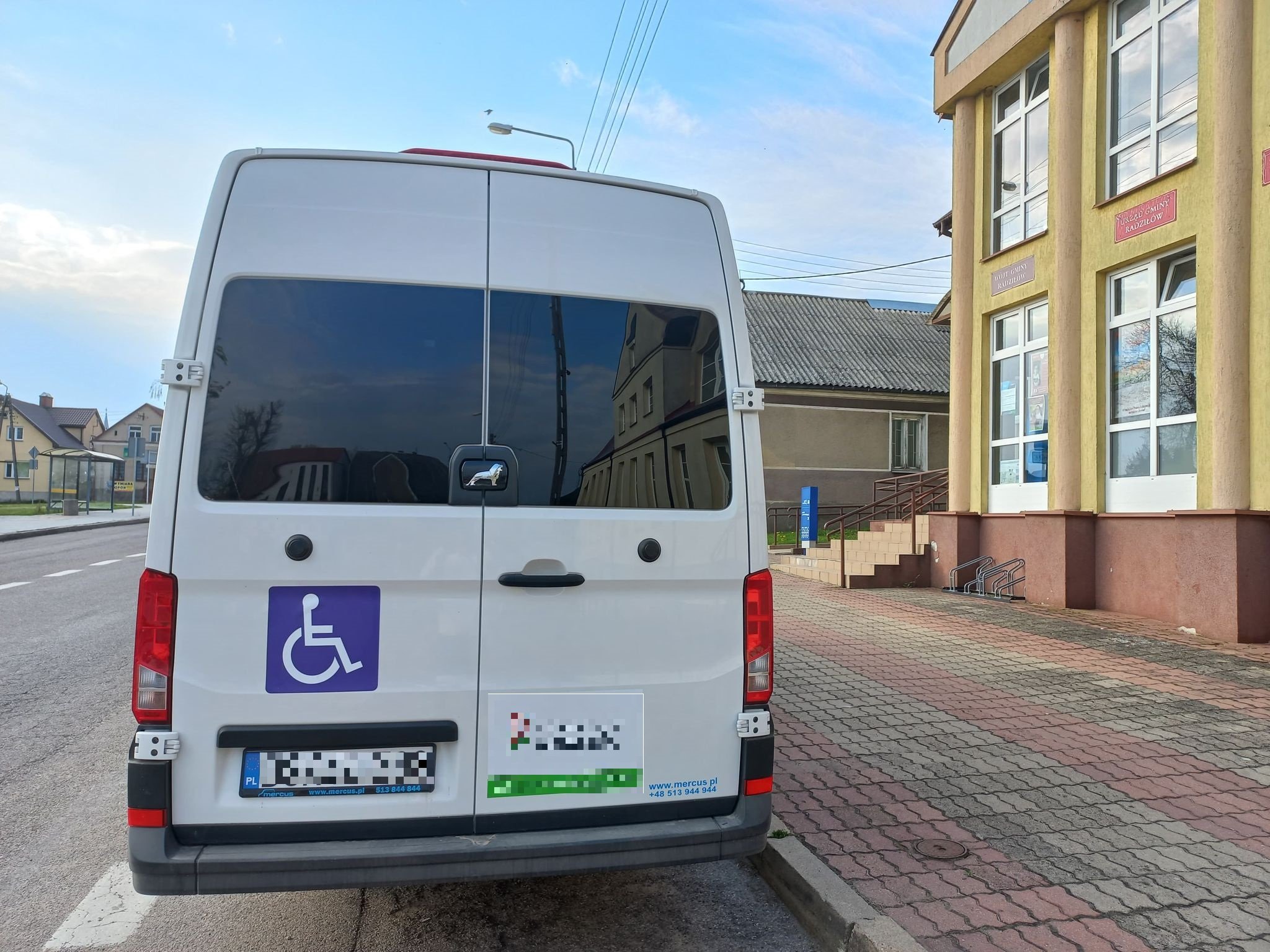 Sytuacja drogowa do pytania: Czy podczas omijania pojazdu oznaczonego taką tablicą i z włączonymi światłami awaryjnymi, z którego wysiada osoba niepełnosprawna należy zachować szczególną ostrożność i w razie potrzeby zatrzymać się?