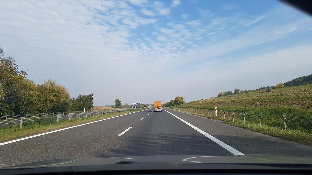 Sytuacja drogowa do pytania: Z jaką maksymalną prędkością kierującemu samochodem osobowym z przyczepą wolno jechać po tej drodze poza obszarem zabudowanym?