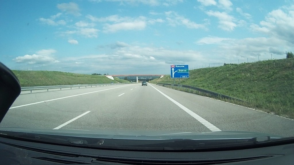 Sytuacja drogowa do pytania: Jaki minimalny odstęp masz obowiązek zachować od jadącego przed Tobą pojazdu, jeżeli poruszasz się samochodem osobowym tą drogą z maksymalną dozwoloną prędkością?
