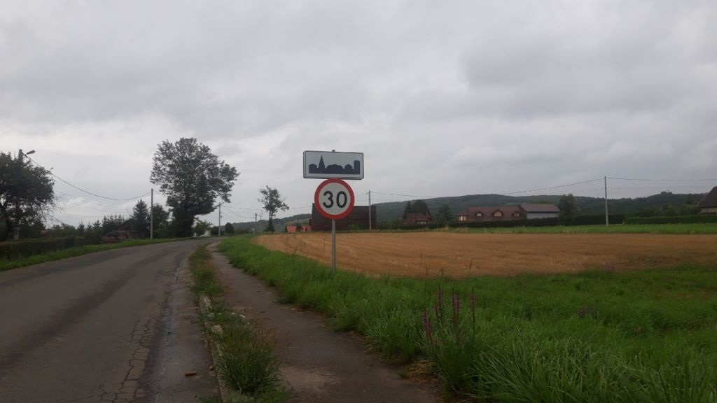 Sytuacja drogowa do pytania: Z jaką prędkością wolno kontynuować jazdę samochodem osobowym za tymi znakami?